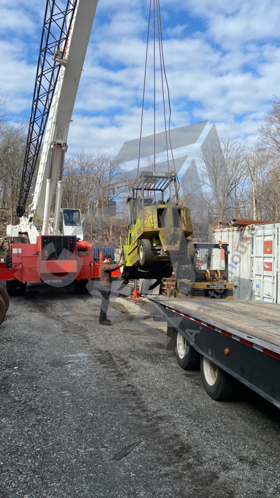 crane loading forklift on truck